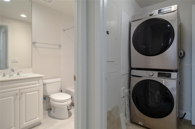 265 Minorca Beach Way Unit 505, New Smyrna Beach, FL 32169 - full bathroom with stacked washing machine and dryer, vanity, toilet, shower / washtub combination, and wood finished floors