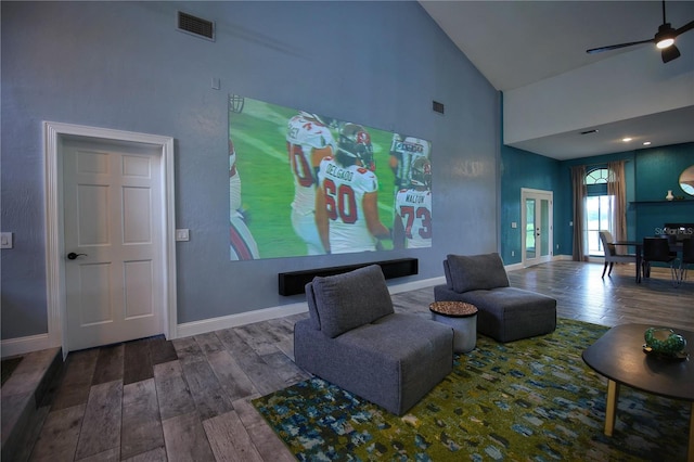 interior space with high vaulted ceiling, wood finished floors, visible vents, and baseboards