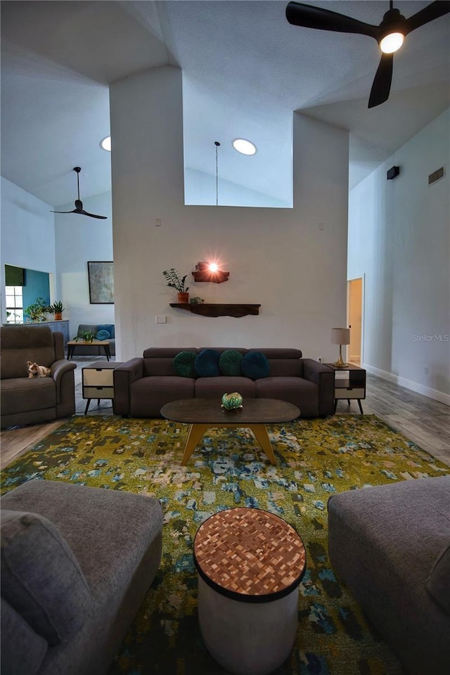 living area featuring high vaulted ceiling, wood finished floors, visible vents, and a ceiling fan