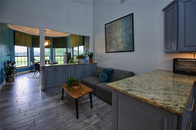 living area featuring a toaster, baseboards, and wood finished floors