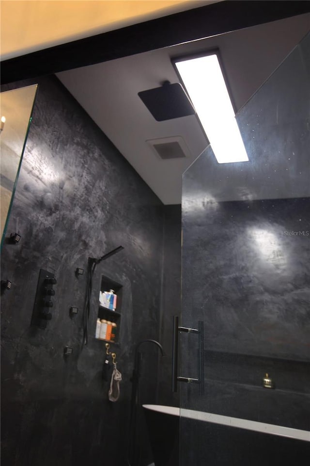 full bathroom featuring finished concrete floors, a marble finish shower, and visible vents