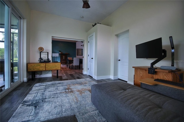 living area with baseboards, vaulted ceiling, and wood finished floors