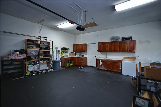 garage featuring refrigerator, a sink, and a garage door opener