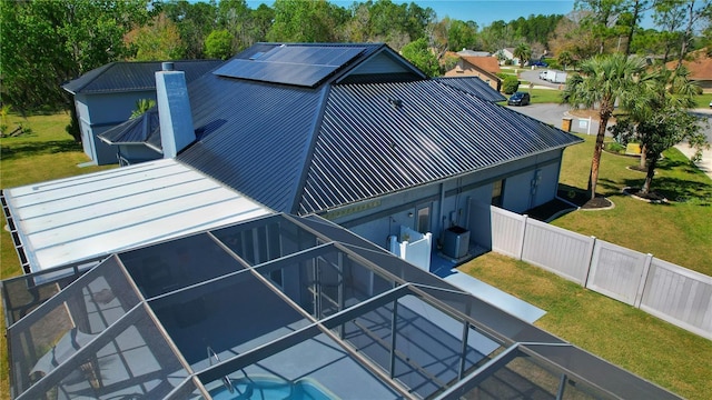 exterior space featuring a fenced backyard, a chimney, metal roof, cooling unit, and a yard