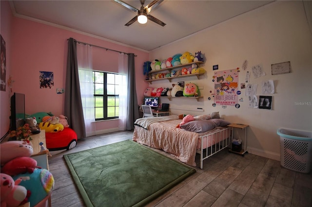 bedroom with baseboards, ceiling fan, wood finished floors, and crown molding