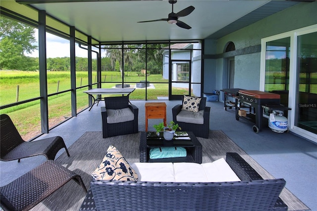 sunroom / solarium featuring ceiling fan