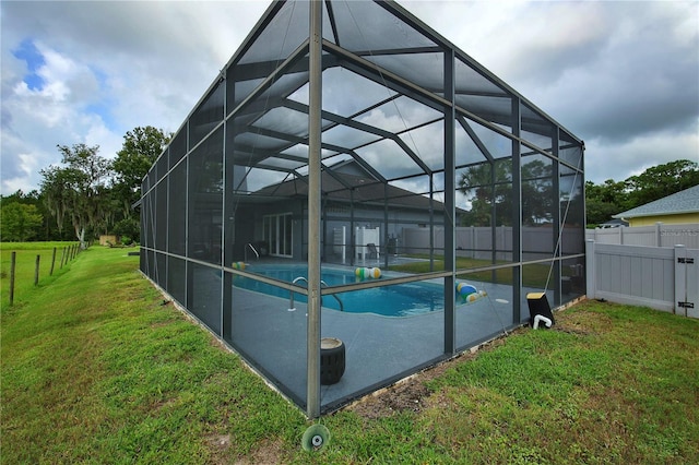 view of swimming pool featuring a lanai, a fenced backyard, a fenced in pool, and a yard