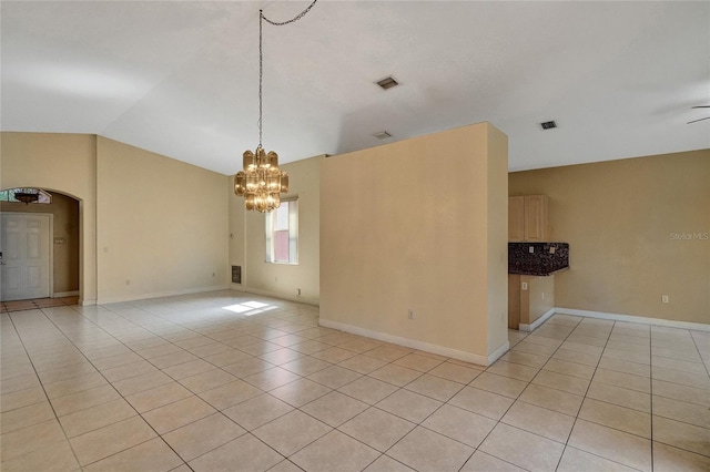 spare room with light tile patterned floors, visible vents, arched walkways, vaulted ceiling, and a notable chandelier