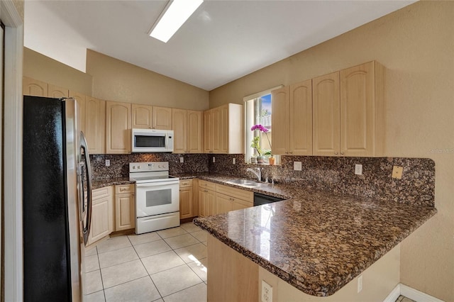 kitchen featuring a peninsula, white appliances, light brown cabinets, and backsplash