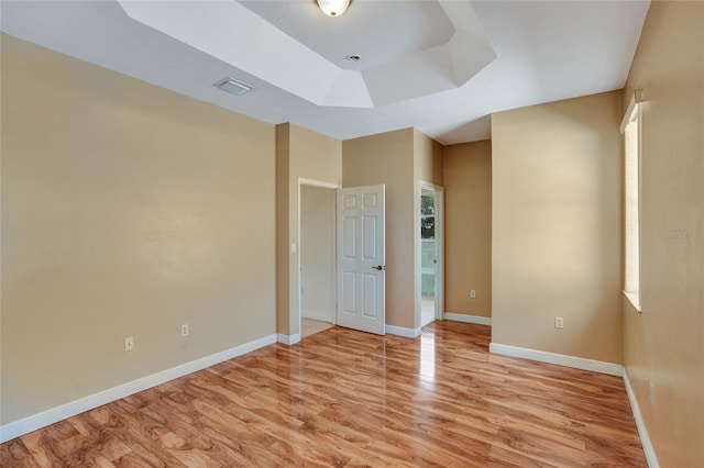 spare room with visible vents, light wood-style flooring, and baseboards