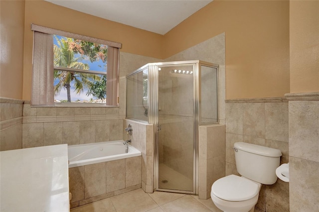 bathroom with a garden tub, a shower stall, tile walls, and tile patterned floors