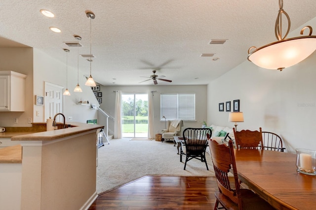 dining area featuring visible vents, a ceiling fan, stairway, a textured ceiling, and light wood-style floors