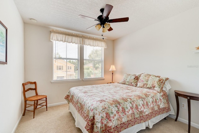 bedroom featuring carpet floors, a ceiling fan, baseboards, and a textured ceiling