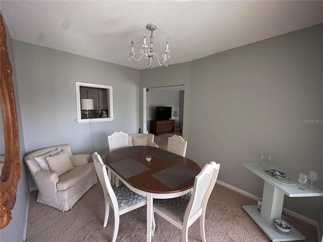 carpeted dining room with baseboards, a textured ceiling, and a notable chandelier