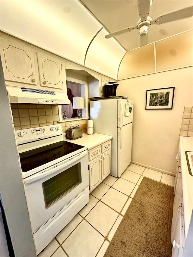 kitchen featuring light tile patterned flooring, under cabinet range hood, white appliances, a ceiling fan, and light countertops