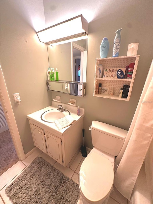 bathroom with toilet, tile patterned flooring, and vanity