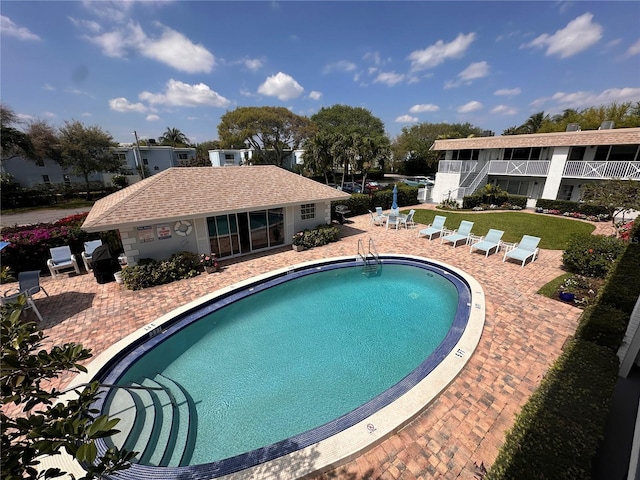 pool with a patio area and a yard