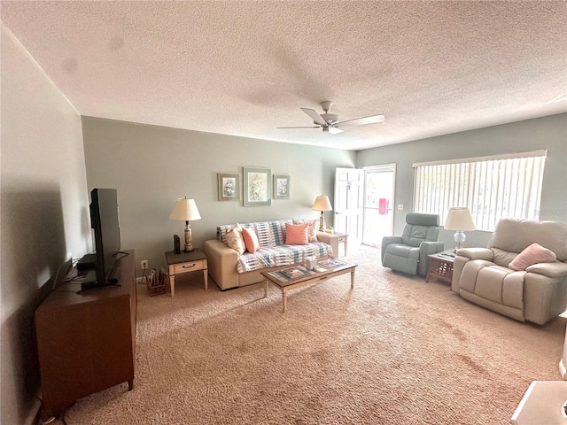 living room with ceiling fan, a textured ceiling, and carpet