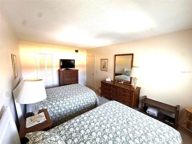 bedroom featuring a textured ceiling and carpet floors