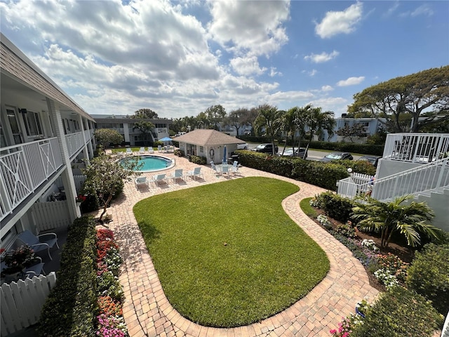 view of yard featuring a patio area, fence, and a community pool