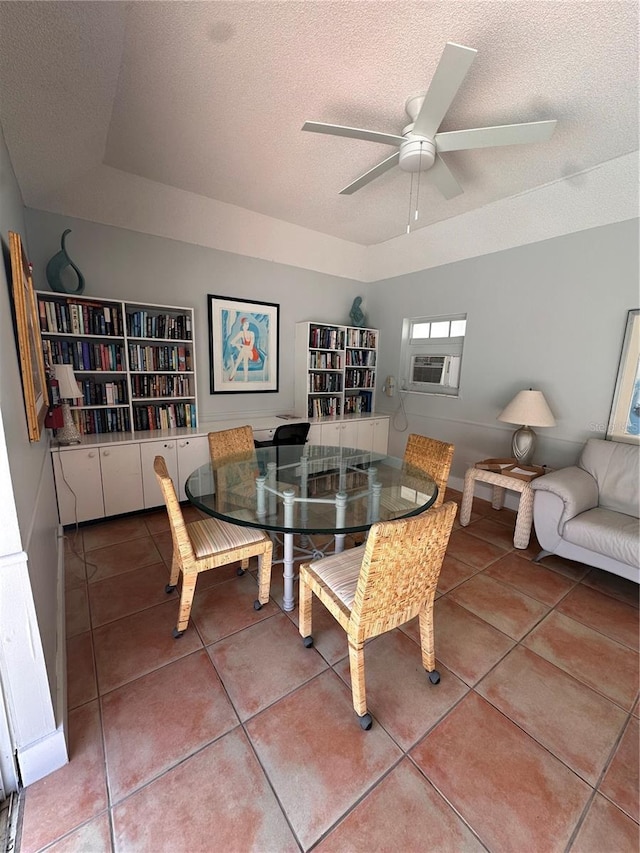 tiled dining room with a ceiling fan, cooling unit, and a textured ceiling