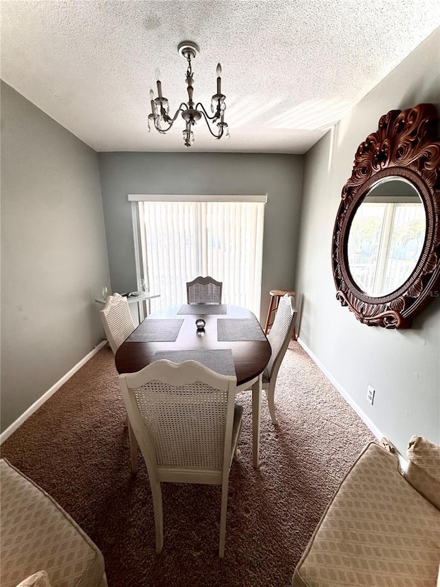 carpeted dining space with a textured ceiling, baseboards, and an inviting chandelier