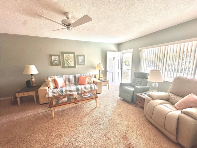 living area featuring carpet, ceiling fan, and a textured ceiling