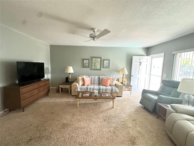 carpeted living area with ceiling fan and a textured ceiling