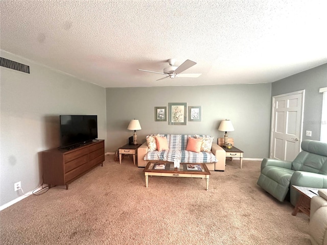 living area with a textured ceiling, carpet flooring, a ceiling fan, and baseboards