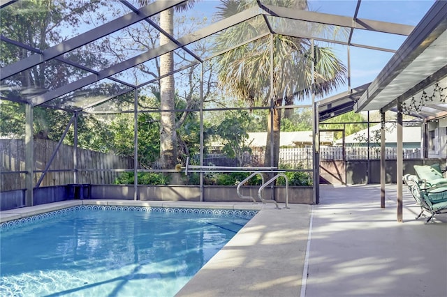 view of pool featuring a patio area, fence, a fenced in pool, and a lanai