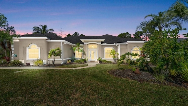 view of front of property featuring a front lawn and stucco siding