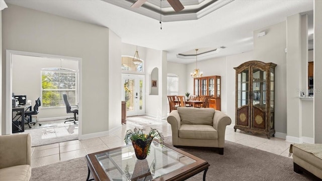 living area featuring arched walkways, ceiling fan with notable chandelier, light tile patterned flooring, and baseboards