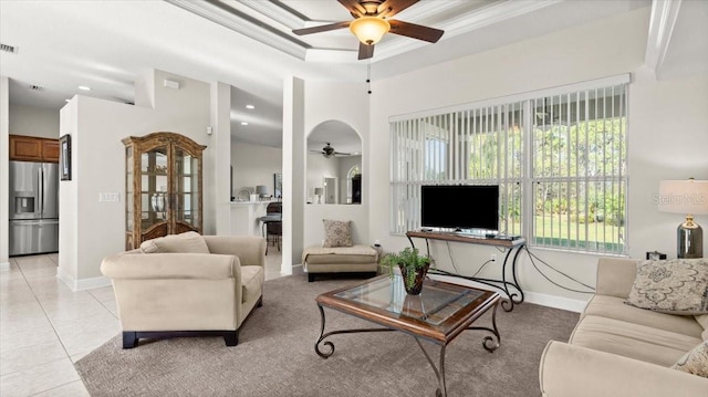 living room featuring light tile patterned floors, visible vents, a ceiling fan, baseboards, and ornamental molding