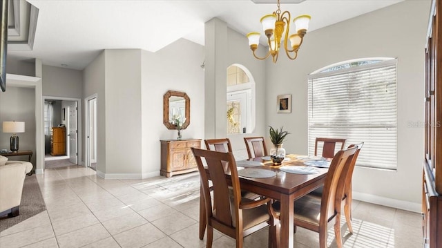 dining space featuring light tile patterned flooring, a notable chandelier, and baseboards