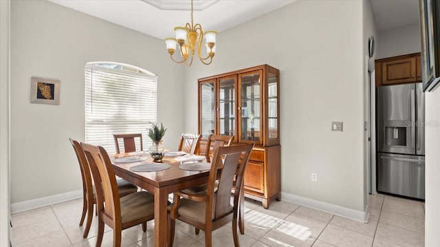 dining space featuring baseboards, light tile patterned flooring, and an inviting chandelier