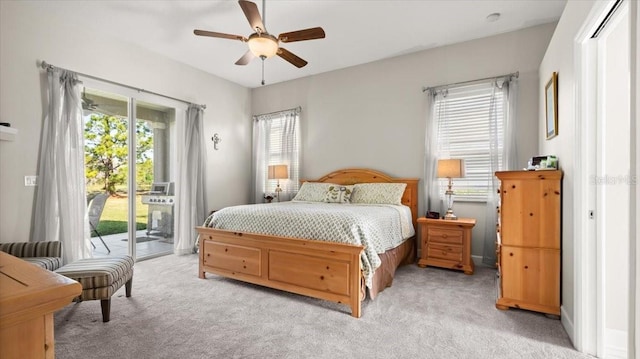 bedroom featuring access to exterior, light colored carpet, and a ceiling fan