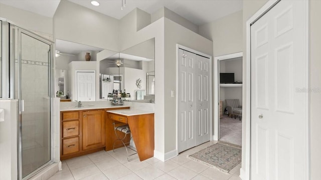 full bath featuring a closet, a ceiling fan, a shower stall, vanity, and tile patterned flooring