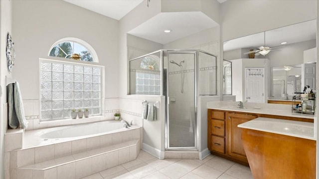 bathroom featuring a ceiling fan, a garden tub, a shower stall, and vanity