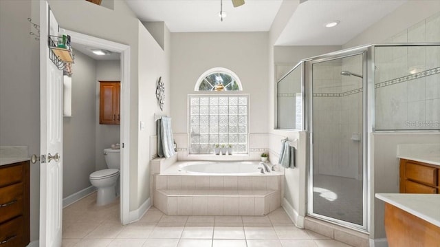 bathroom featuring tile patterned flooring, toilet, a garden tub, vanity, and a stall shower