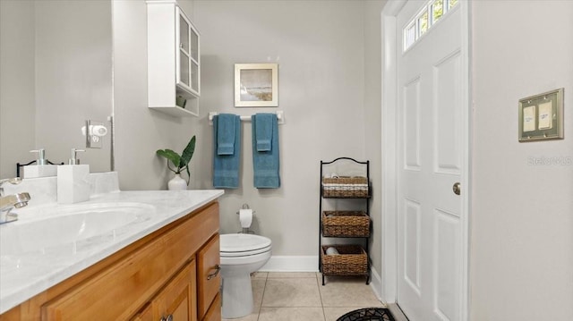 bathroom featuring baseboards, vanity, toilet, and tile patterned floors