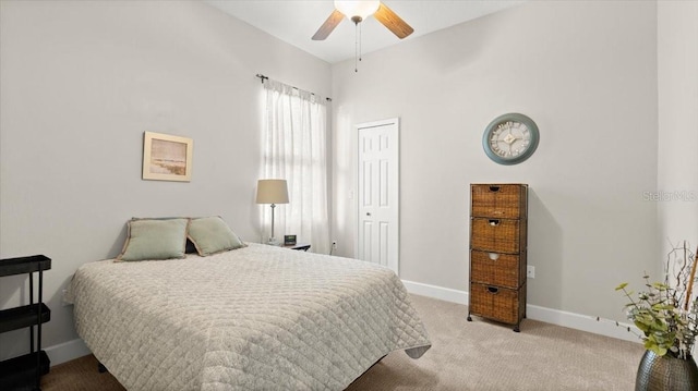 carpeted bedroom with ceiling fan, a closet, and baseboards