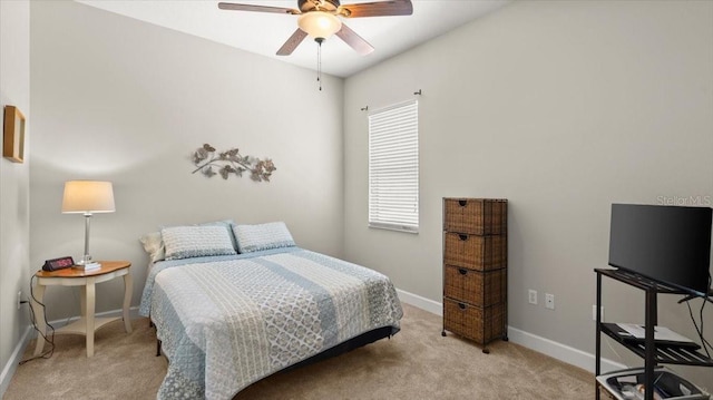 carpeted bedroom with ceiling fan and baseboards