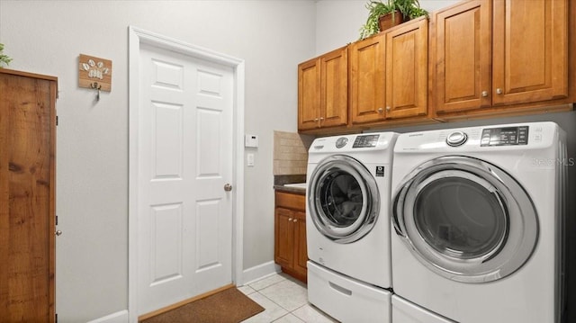 laundry area with washer and dryer, cabinet space, and light tile patterned flooring