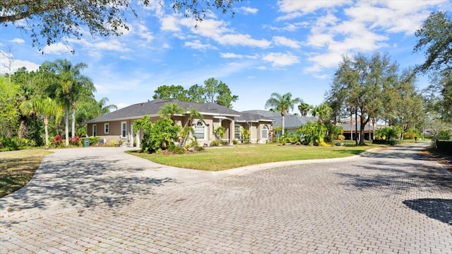 single story home with decorative driveway and a front yard