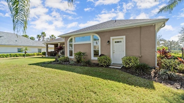 view of front facade featuring a front yard and stucco siding