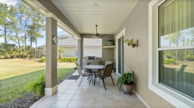 view of patio / terrace featuring a ceiling fan and glass enclosure