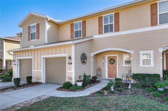 multi unit property featuring a garage, board and batten siding, and concrete driveway