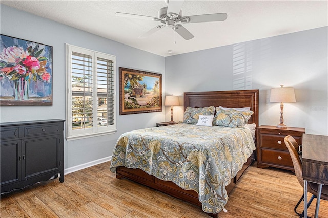 bedroom with ceiling fan, light wood finished floors, and baseboards