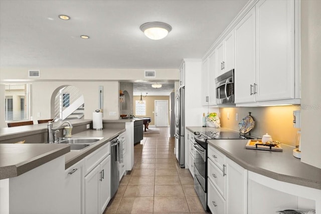 kitchen featuring light tile patterned floors, visible vents, appliances with stainless steel finishes, white cabinetry, and a sink