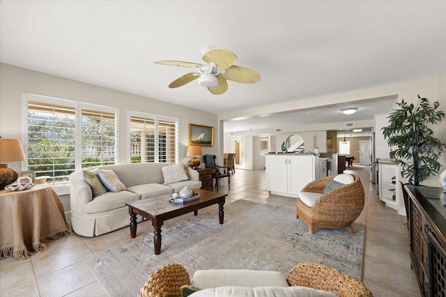 living room featuring a ceiling fan, visible vents, and light tile patterned floors